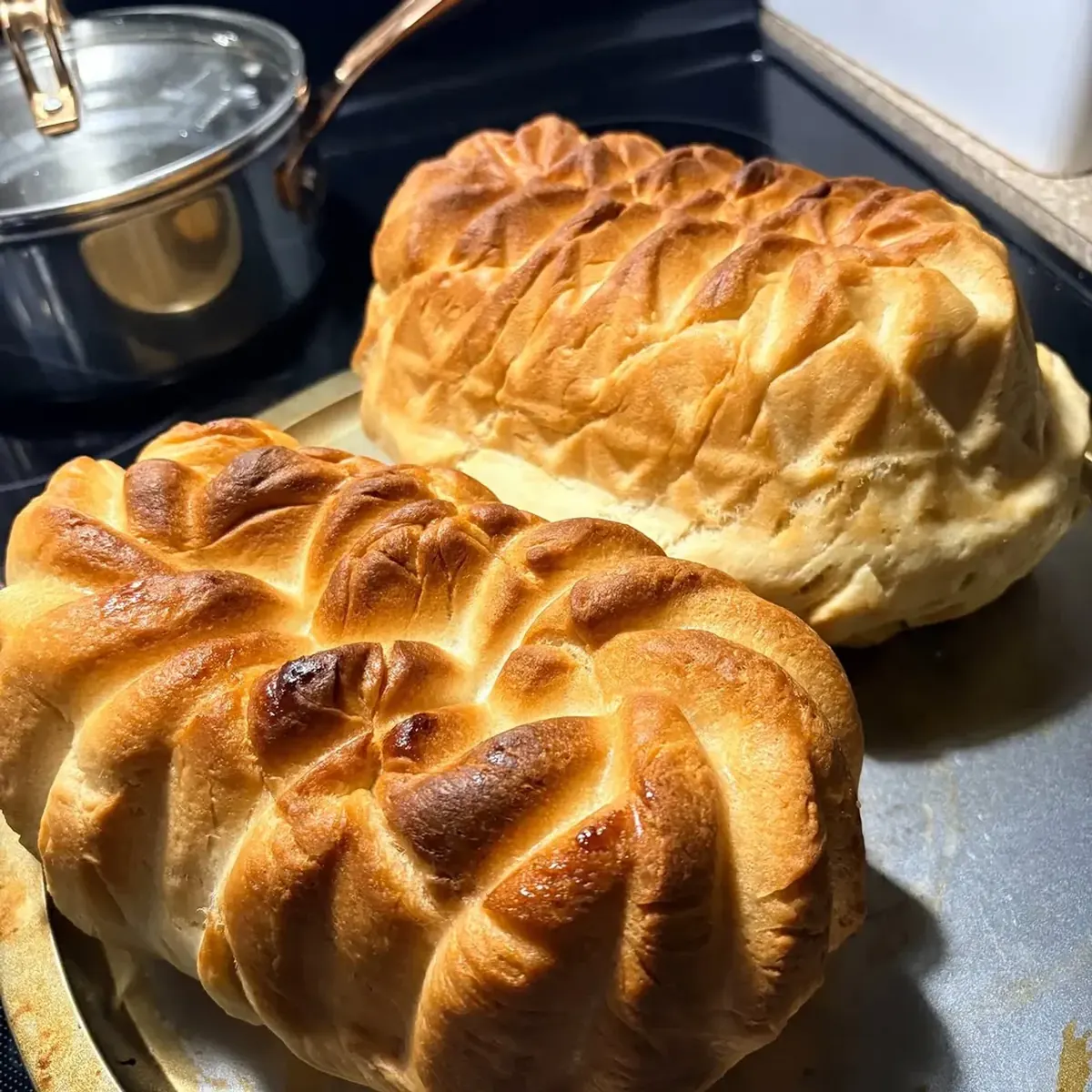 Two golden braided loaves of white bread fresh from the oven