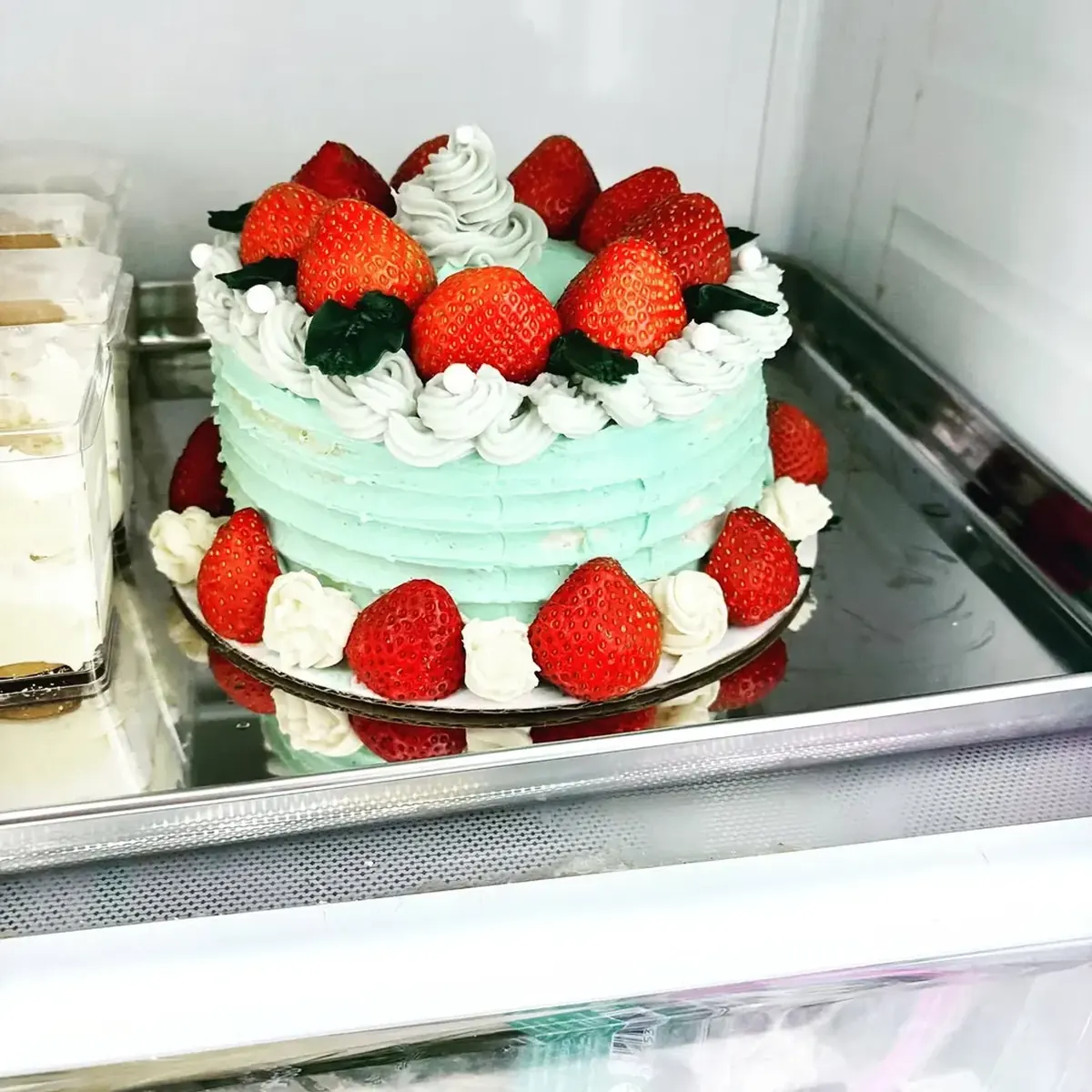 Mint green layer cake crowned with fresh strawberries