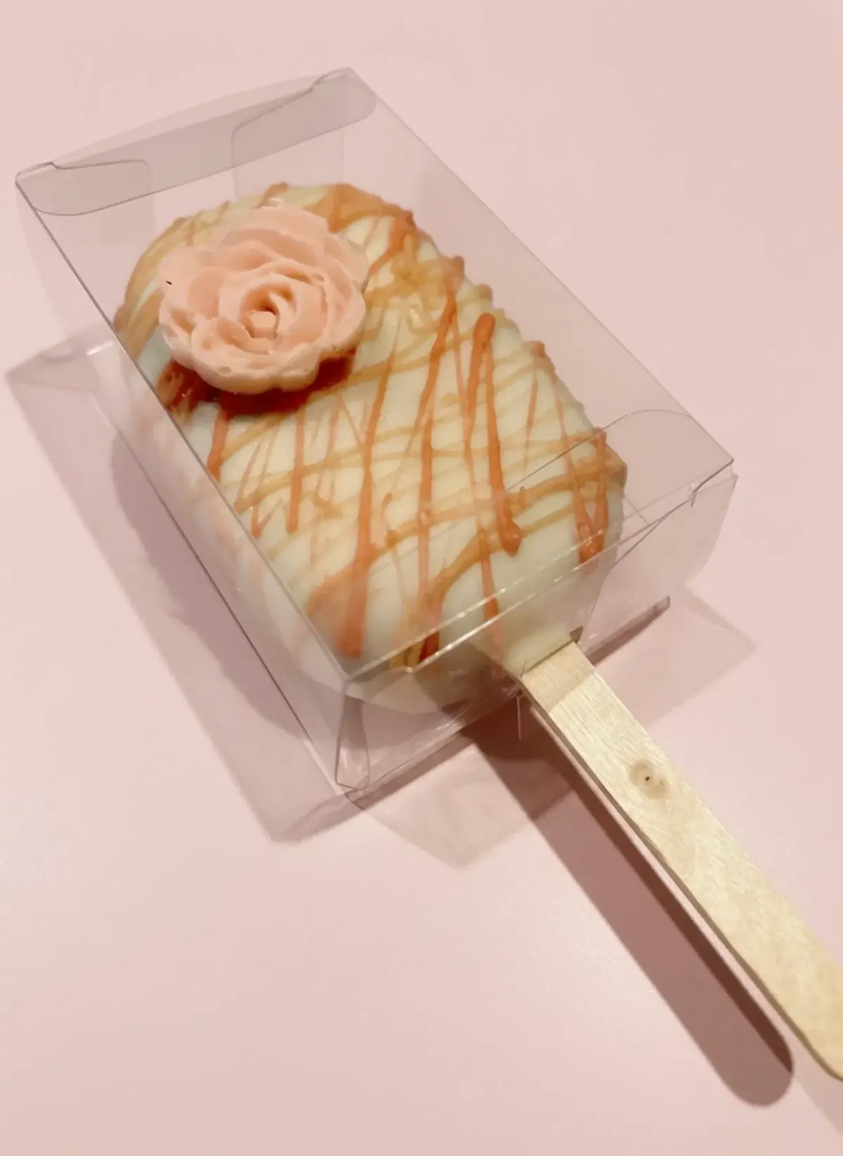 Cakesicle with caramel drizzle and a piped rose