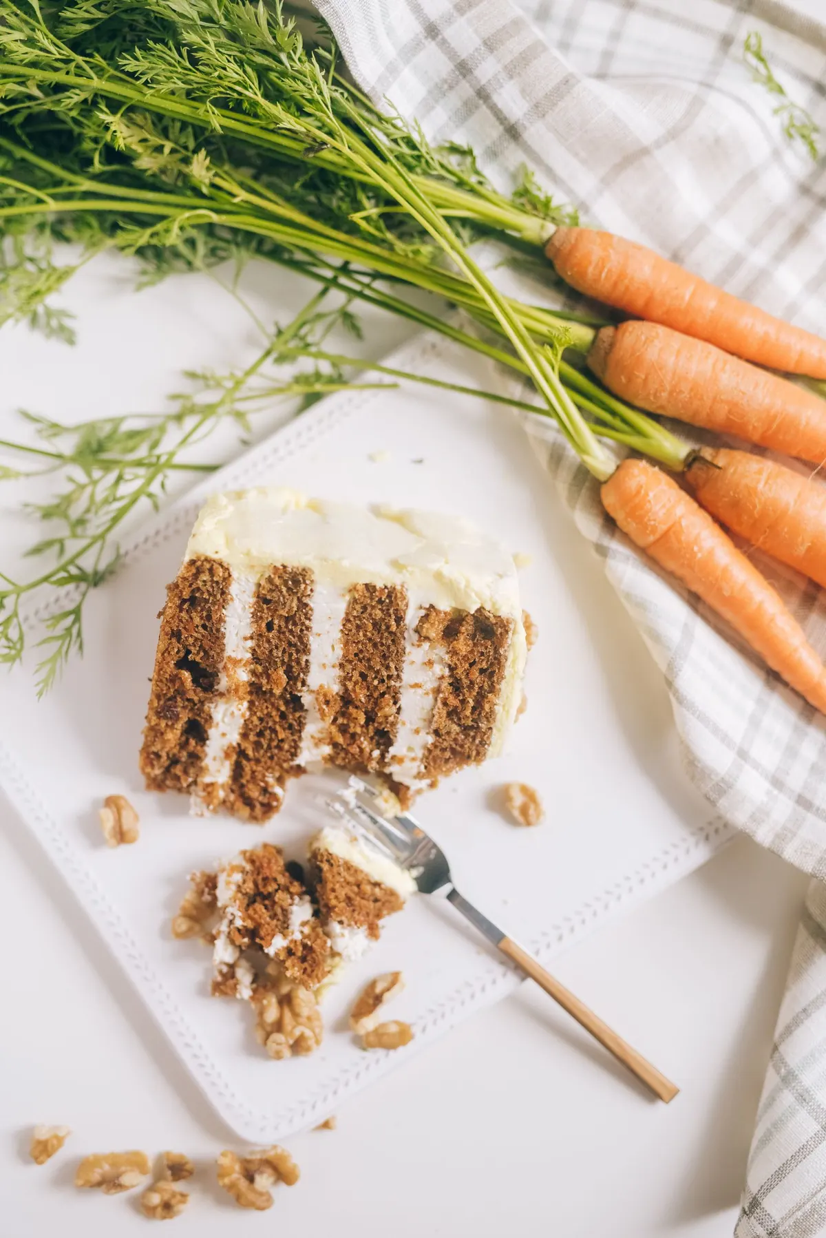 Slice of layered carrot cake with cream cheese frosting
